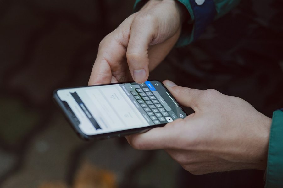 スマートフォンを両手で操作する手元